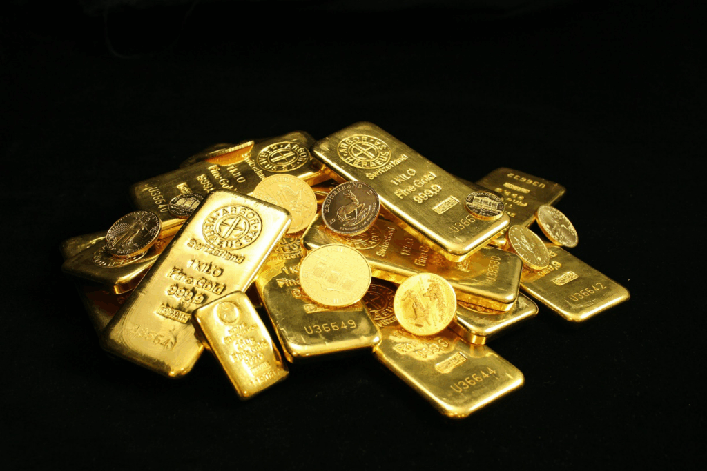 Gold coins and bars on a black surface