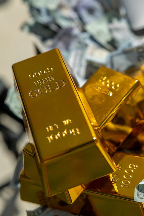 Gold bars with money in the background